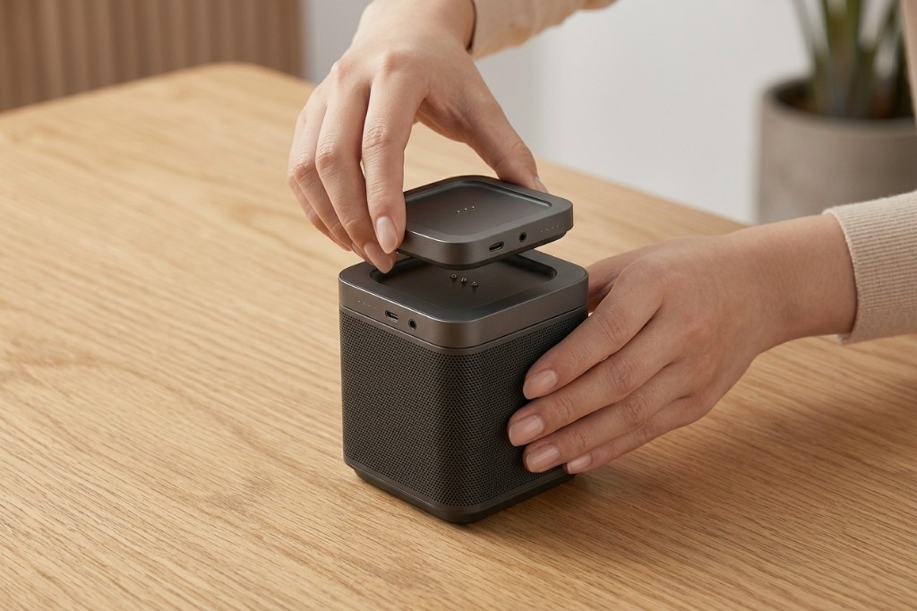 Hands docking the puck onto the Echo 01 speaker